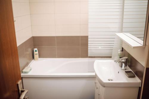 een badkamer met een wit bad en een wastafel bij Adrian Home Mega in Ploieşti