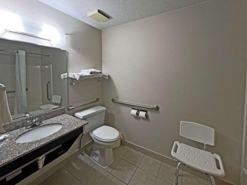 a bathroom with a toilet and a sink and a mirror at Quality Inn Mitchell I-90 in Mitchell