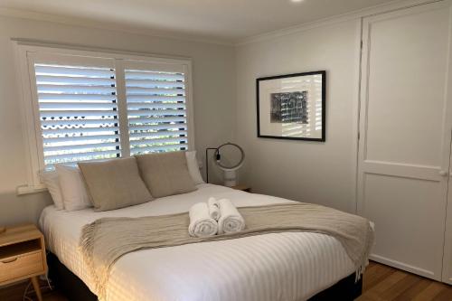 a bedroom with a bed with two towels on it at HIDDEN HAVEN Binalong Bay in Binalong Bay