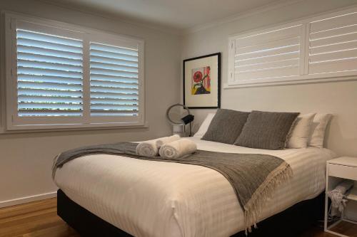 a bedroom with a large white bed with two pillows at HIDDEN HAVEN Binalong Bay in Binalong Bay