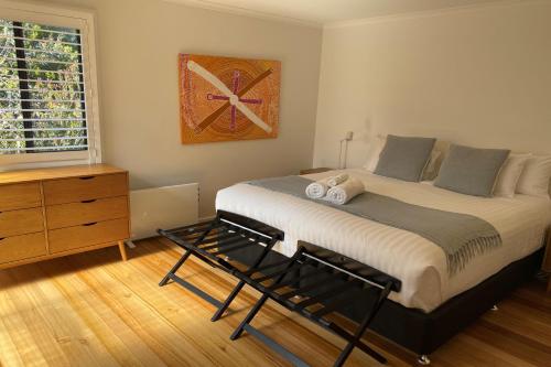 a bedroom with a large bed and a dresser at HIDDEN HAVEN Binalong Bay in Binalong Bay