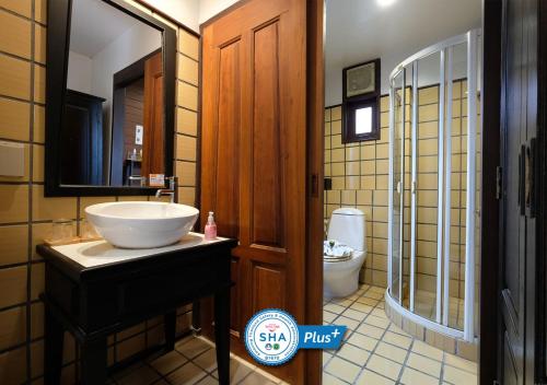 a bathroom with a sink and a toilet at Baan Amphawa Resort & Spa - SHA Certified in Amphawa