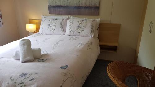 a bedroom with a white bed with flowers on it at Mountain View in Millom
