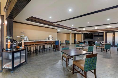 un ristorante con tavoli e sedie e un bar di Comfort Suites Gainesville a Gainesville
