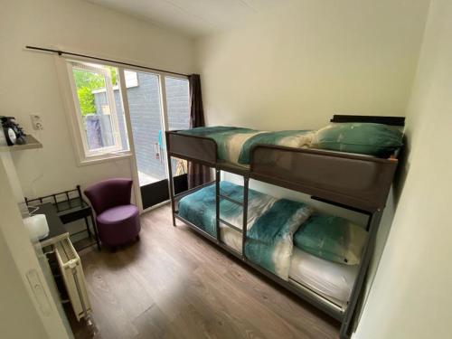 a room with two bunk beds and a window at Strandhuisje Ermerzand in Erm