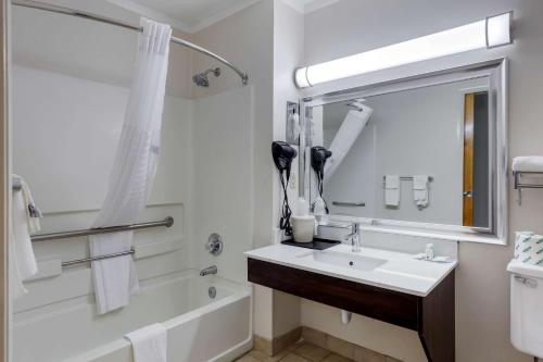 a bathroom with a sink and a tub and a mirror at Quality Inn - Roxboro South in Roxboro