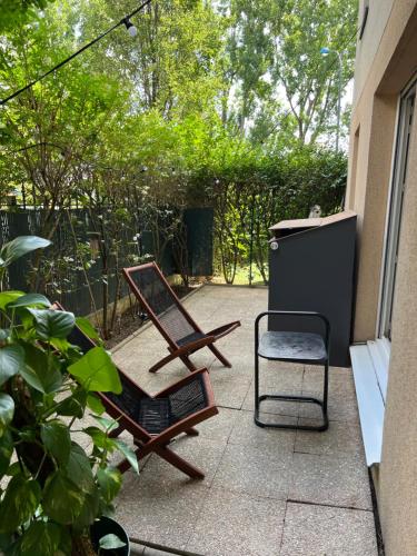 a patio with a chair and a table and a chair at Charme et Passion By UTA HOUSE in Saint-Denis