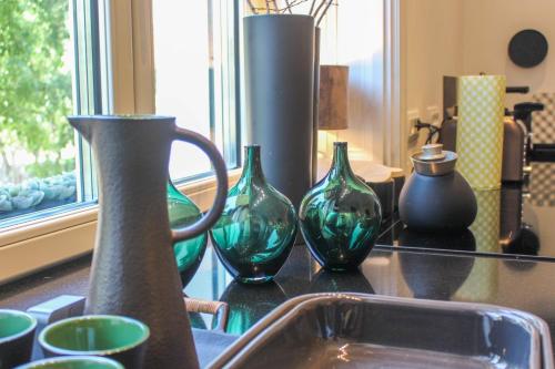 a group of green glass vases sitting on a counter at Valsabbion Deluxe City Suite in Pula