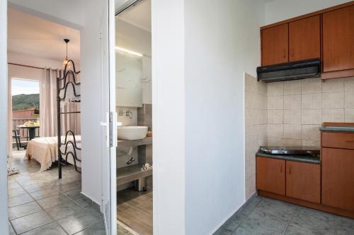a kitchen with brown cabinets and a bathroom at Studios Halkia in Toroni