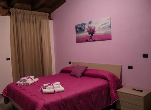 a bedroom with a pink bed with two towels on it at B&B Bellavista in Celano