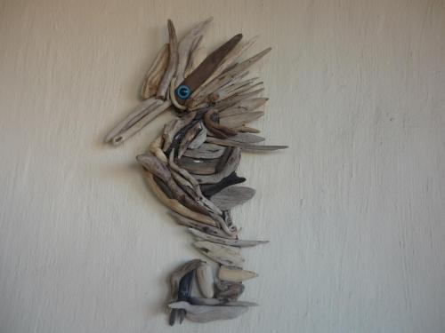 a bunch of dried plants on a wall with a blue bead at A1 Kynaston Guest House bed and breakfast or self catering in Jeffreys Bay