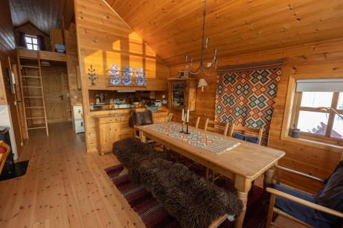 a dining room with a table and chairs in a cabin at Myraleited 40 in Tjørhom