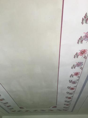 a white ceiling with flowers painted on it at Il Melograno Country House in Saturnia