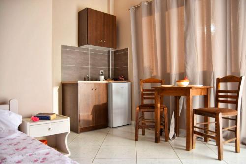 uma pequena cozinha com uma mesa e um frigorífico em Anemomylos Apartments em Lixúri