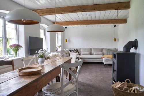 een woonkamer met een tafel en een bank bij Reetdachhaus De Ole Kaat in Niesgrau