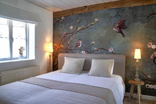 een slaapkamer met een bed met een bloemenmuur bij Reetdachhaus De Ole Kaat in Niesgrau