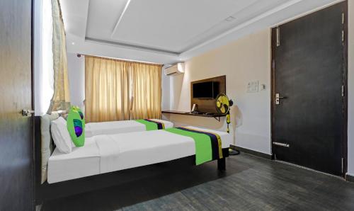 a hotel room with two beds and a television at Treebo JJ Residency in Bengaluru