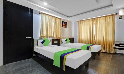 a hotel room with two beds and a window at Treebo JJ Residency in Bengaluru