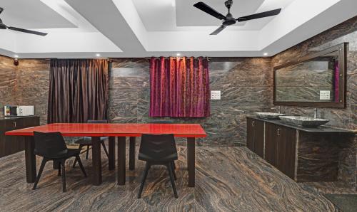 a dining room with a red table and chairs at Treebo JJ Residency in Bengaluru