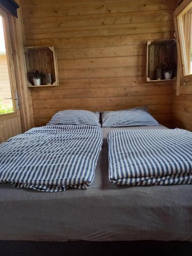 1 dormitorio con 2 camas en una pared de madera en 't Zwientje, en Ermelo