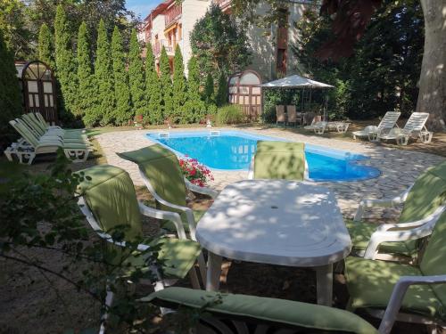 a table and chairs next to a swimming pool at Apartman Orgona in Siófok