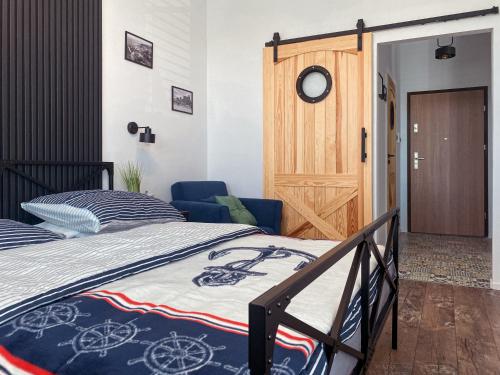 a bedroom with a bed and a wooden door at Apartament TURKUS in Puck