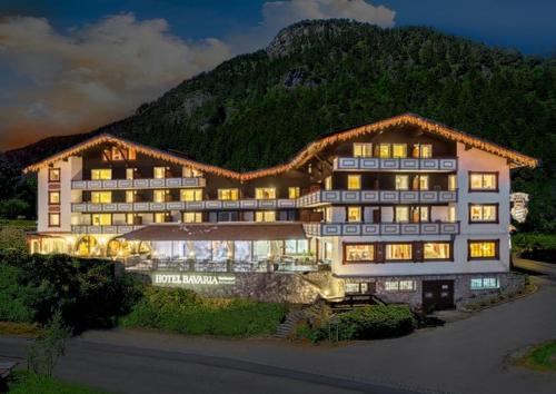 a large hotel with a mountain in the background at Familotel Bavaria Pfronten-Familien Hotel-Alles Inklusive Konzept in Pfronten