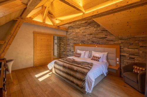 a bedroom with a bed and a stone wall at Hôtel National Resort & Spa in Champéry