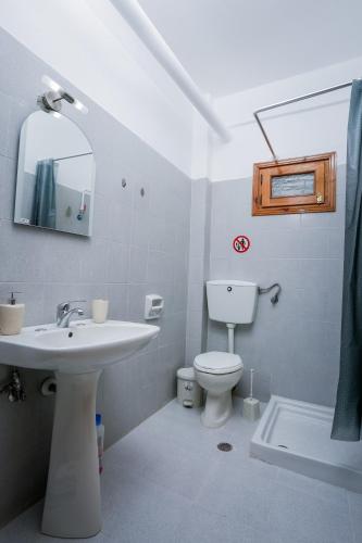 a bathroom with a sink and a toilet and a mirror at GK Houses #2 in Asprovalta