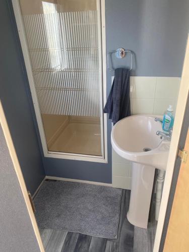 a small bathroom with a shower and a sink at 187 sealands in Ingoldmells
