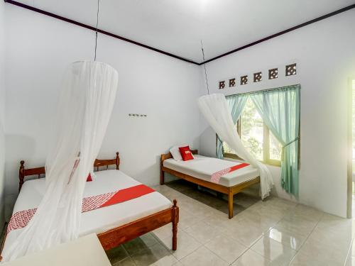 Tempat tidur dalam kamar di OYO 90924 Tarsius Homestay