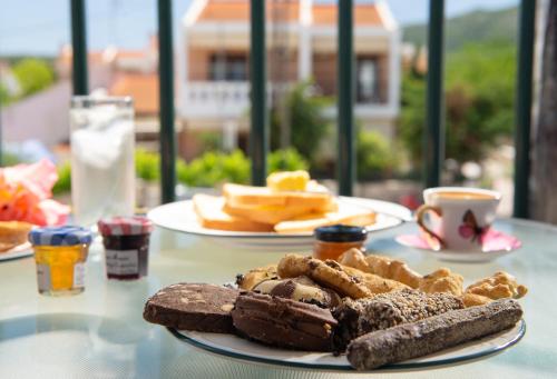 a table with two plates of bread and cookies on it at Studios Halkia in Toroni