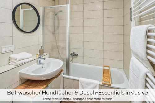 La salle de bains est pourvue d'un lavabo, d'une baignoire et d'un miroir. dans l'établissement "Grüne Oase" - Nähe Altstadt - Garage - Ruhig - Nespresso, à Dresde