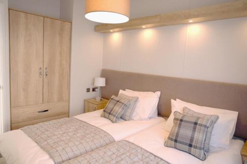 a bedroom with a bed with white sheets and pillows at Trefalun Park in Tenby
