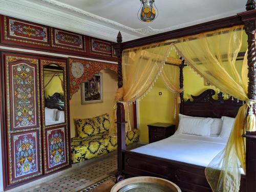 a bedroom with a canopy bed in a room at Malabata Guest House in Tangier