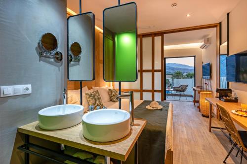 uma casa de banho com 2 lavatórios numa mesa de madeira em Georgioupolis Suites em Georgioupolis