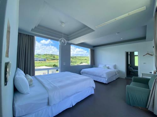 a bedroom with two beds and a large window at 墾丁花見小院Villa包棟民宿 in Eluan