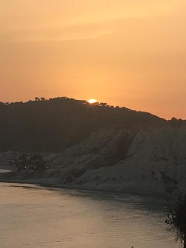a sunset over a hill with the sun setting on it at Villa Maria Sofia in Realmonte