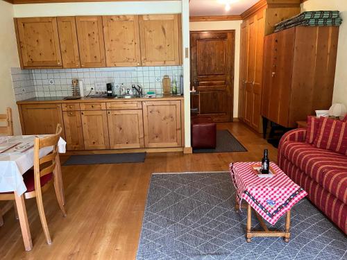 a kitchen and a living room with a couch and a table at Studio - La Vièze Thermes Park in Val dʼIlliez