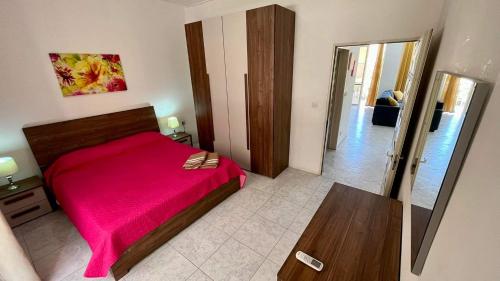 1 dormitorio con 1 cama con manta roja en Sea view and valley view flat in Marsalforn, en Marsalforn