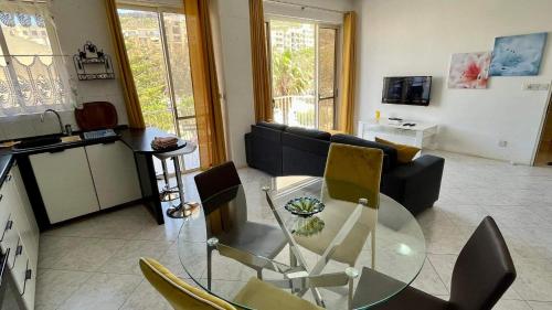 uma sala de estar com uma mesa de vidro e um sofá em Sea view and valley view flat in Marsalforn em Marsalforn