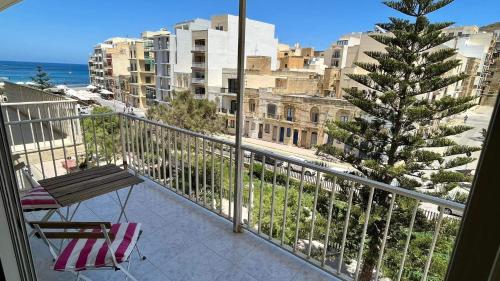 een balkon met een bank en een boom op een stad bij Sea view and valley view flat in Marsalforn in Marsalforn