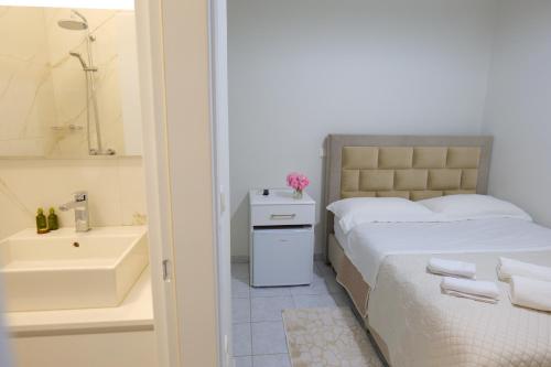 1 dormitorio con 1 cama y baño con lavamanos en Saranda Landscape en Sarandë