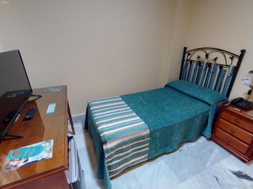 a small bedroom with a bed and a dresser at Hotel La Parrita in Rota