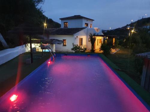 a swimming pool with red lights in front of a house at Casa del rio in Málaga