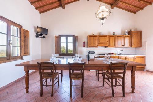 a large kitchen with a wooden table and chairs at Villa Boscone by Mmega in Querce