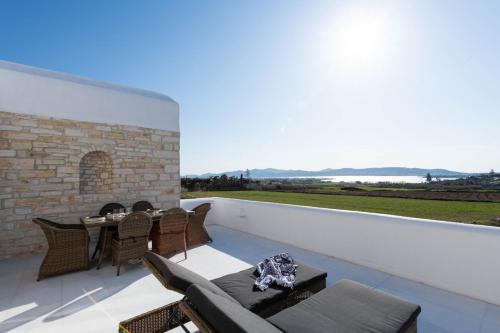 a patio with a table and chairs on a balcony at Sersi Paros Villas & Suites in Kampos Paros