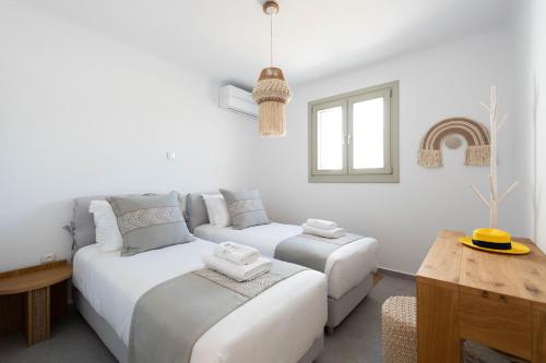 a white living room with two beds and a couch at Sersi Paros Villas & Suites in Kampos Paros