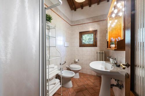 a bathroom with a toilet and a sink at Villa Boscone by Mmega in Querce