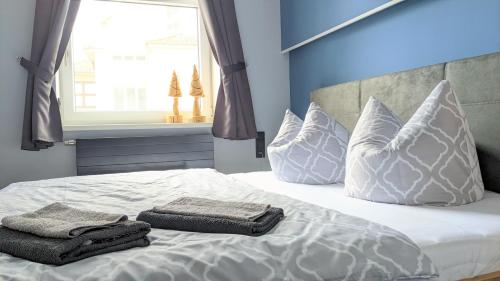 a white bed with pillows and towels on it at Goethes liebste Betten - stilvolle Ferienwohnungen im historischen Fachwerkhaus in Wernigerode - Parkplatz, Smart-TV, W-Lan in Wernigerode